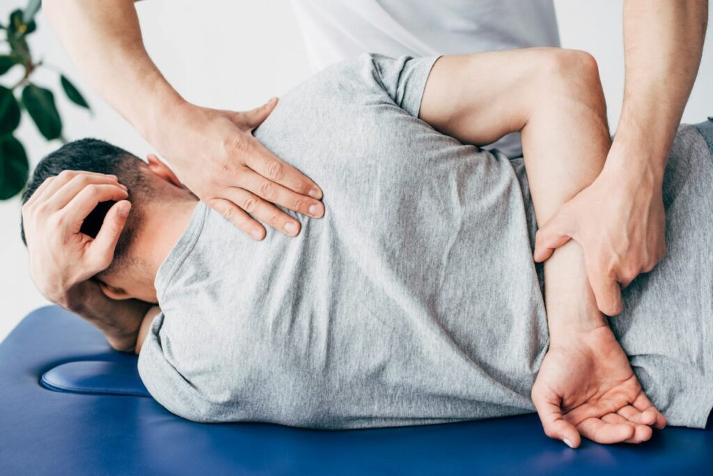 back-view-of-chiropractor-massaging-back-of-man-lying-on-massage-table-in-hospital.jpg